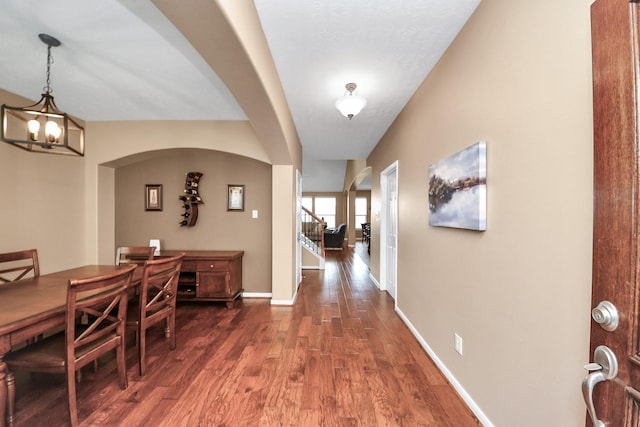 7603 Chimney Gap, Missouri City, TX 77459 - dining space with an inviting chandelier, arched walkways, baseboards, and wood finished floors
