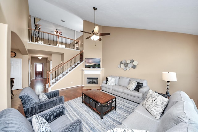 7603 Chimney Gap, Missouri City, TX 77459 - living room with a ceiling fan, arched walkways, wood finished floors, stairway, and a glass covered fireplace