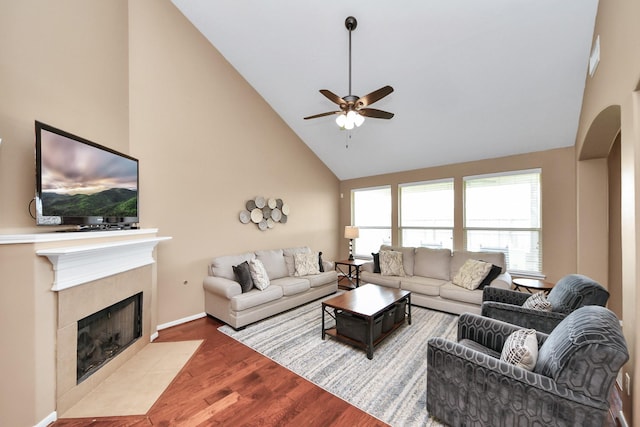7603 Chimney Gap, Missouri City, TX 77459 - living room featuring a fireplace, arched walkways, high vaulted ceiling, a ceiling fan, and wood finished floors