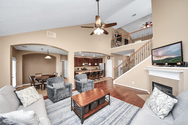 7603 Chimney Gap, Missouri City, TX 77459 - living room with ceiling fan, visible vents, arched walkways, a fireplace, and wood finished floors