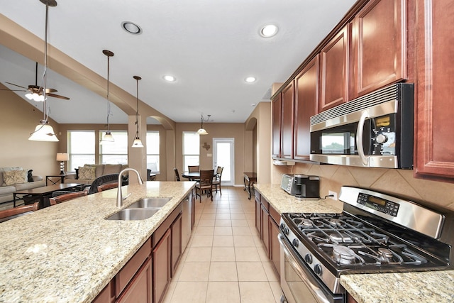 7603 Chimney Gap, Missouri City, TX 77459 - kitchen with a sink, appliances with stainless steel finishes, arched walkways, and a healthy amount of sunlight