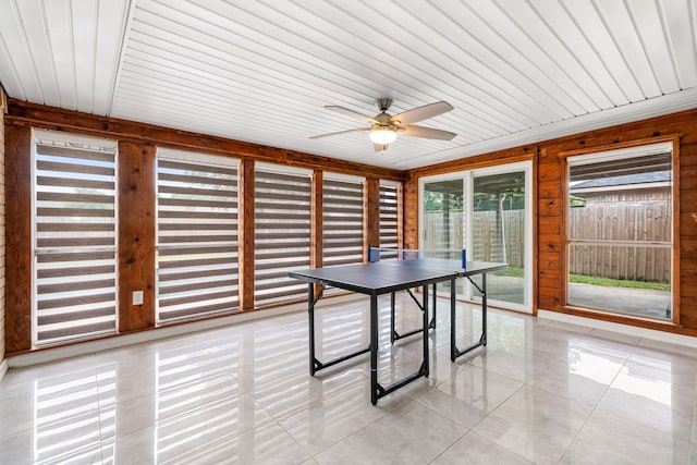 playroom featuring light tile patterned floors, wooden ceiling, ceiling fan, and wood walls