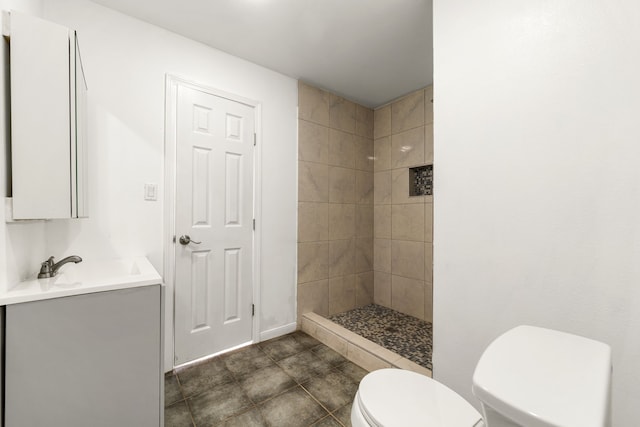 full bathroom with vanity, toilet, and tiled shower