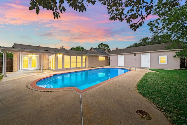 outdoor pool featuring a lawn, a patio, fence, and french doors
