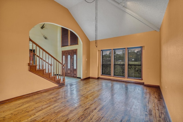 7739 County Road 684, Sweeny, TX 77480 - entrance foyer featuring arched walkways, high vaulted ceiling, stairs, baseboards, and wood finished floors