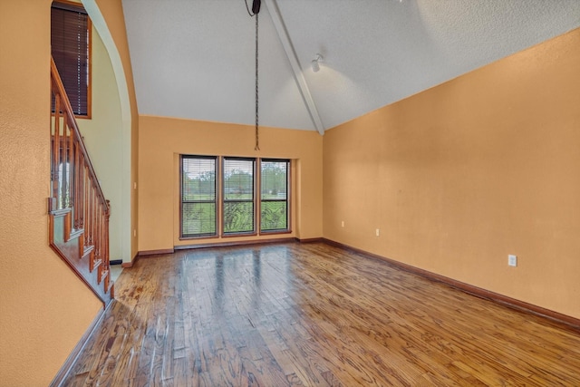 7739 County Road 684, Sweeny, TX 77480 - unfurnished living room featuring baseboards, stairs, wood finished floors, and high vaulted ceiling