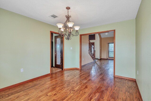 7739 County Road 684, Sweeny, TX 77480 - unfurnished room featuring visible vents, baseboards, stairway, a chandelier, and light wood-style flooring