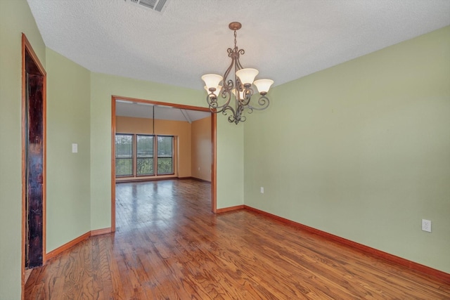 7739 County Road 684, Sweeny, TX 77480 - empty room featuring a chandelier, wood finished floors, and a textured ceiling