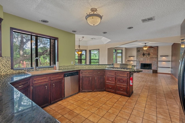 7739 County Road 684, Sweeny, TX 77480 - kitchen with open floor plan, ceiling fan, a large fireplace, a sink, and appliances with stainless steel finishes