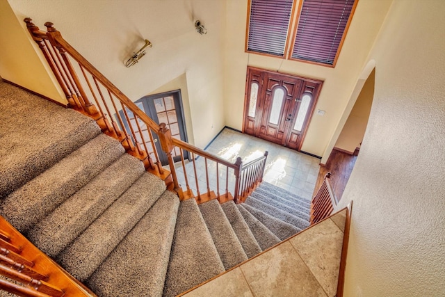 7739 County Road 684, Sweeny, TX 77480 - entrance foyer featuring arched walkways, baseboards, tile patterned floors, a high ceiling, and stairs