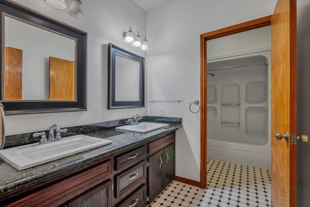 7739 County Road 684, Sweeny, TX 77480 - bathroom featuring double vanity, a sink, baseboards, and shower / bath combination