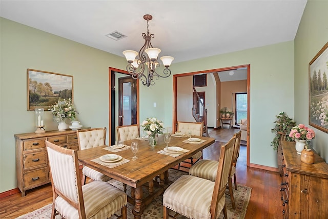 7739 County Road 684, Sweeny, TX 77480 - dining space with a chandelier, wood finished floors, and stairs