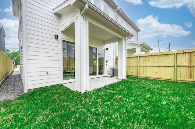 rear view of house with a lawn, a patio, and a fenced backyard