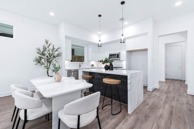 dining area with recessed lighting, baseboards, light wood-type flooring, and visible vents
