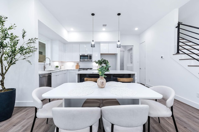 dining room with baseboards, recessed lighting, stairs, and wood finished floors