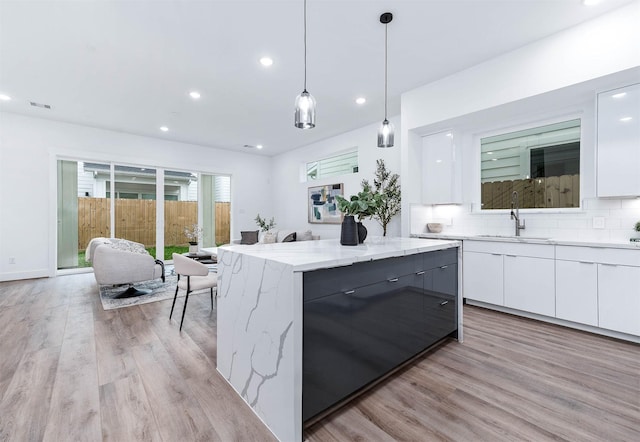kitchen with a sink, white cabinetry, and modern cabinets