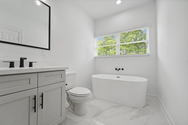 5013 Golden Forest Dr, Houston, TX 77091 - bathroom featuring a freestanding bath, vanity, marble look tile flooring, toilet, and baseboards