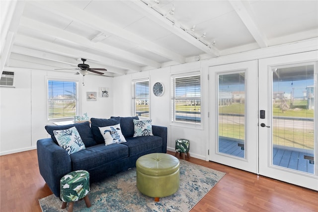 living area with beamed ceiling, a wealth of natural light, and wood finished floors