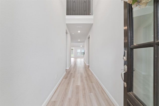 hall featuring light wood-type flooring and baseboards