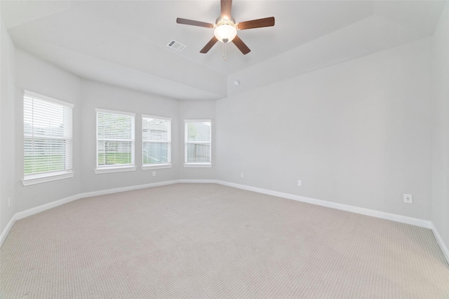 empty room with baseboards, visible vents, light carpet, and ceiling fan
