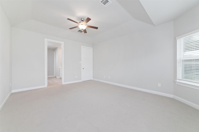 unfurnished bedroom featuring baseboards, visible vents, light carpet, and vaulted ceiling