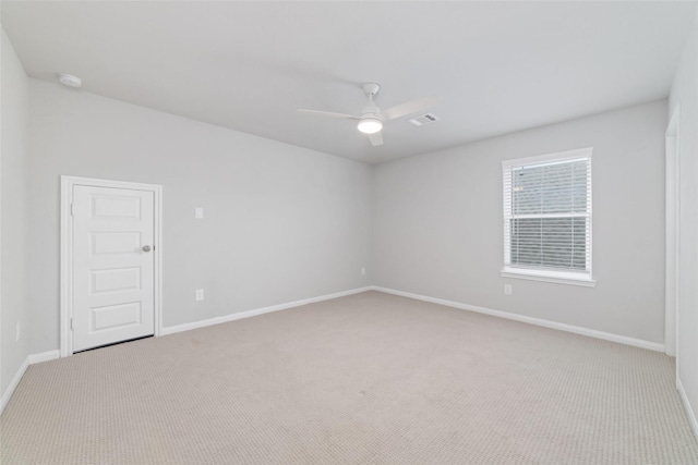 unfurnished room featuring a ceiling fan, baseboards, light colored carpet, and visible vents