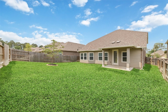 rear view of house with a fenced backyard, a patio, and a yard