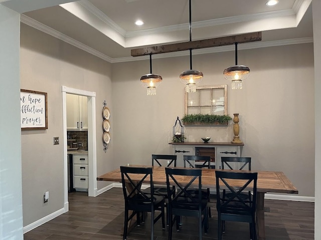 dining room with crown molding, baseboards, a tray ceiling, and dark wood-style flooring