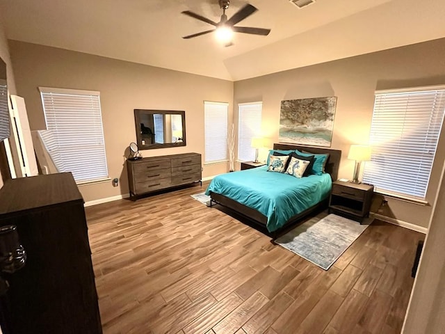 bedroom with baseboards, ceiling fan, vaulted ceiling, and wood finished floors