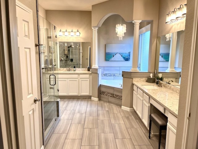 bathroom with a sink, decorative columns, two vanities, and a shower stall