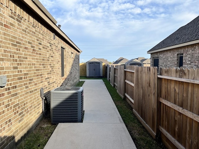 view of home's exterior featuring an outdoor structure, a fenced backyard, a shed, brick siding, and central air condition unit