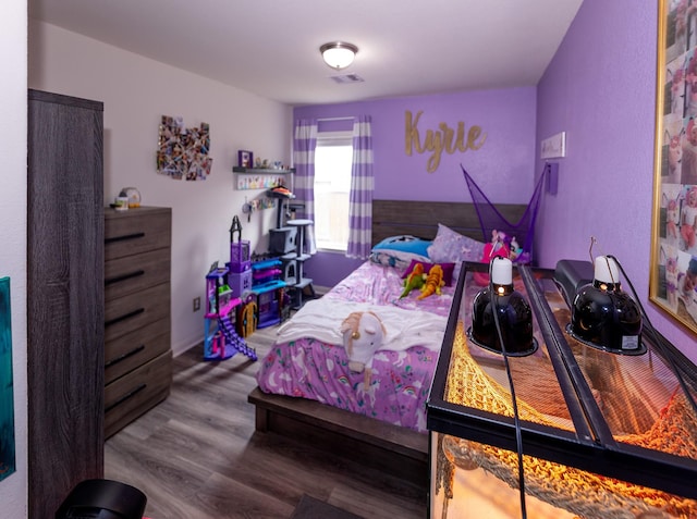 bedroom featuring wood finished floors and visible vents