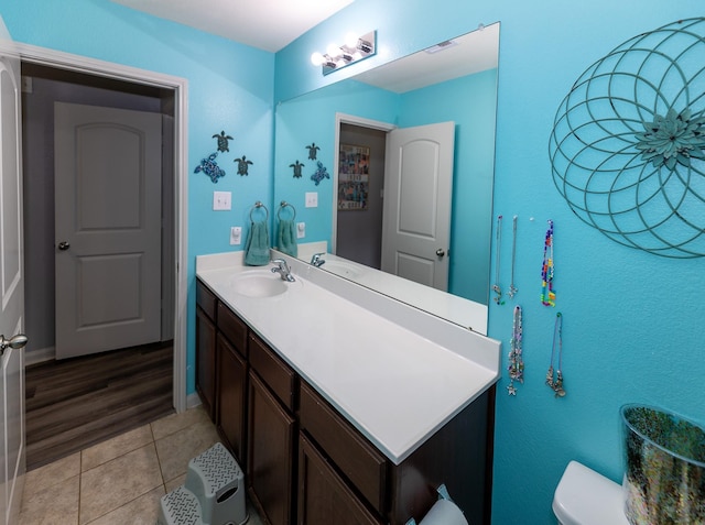 bathroom with tile patterned flooring, vanity, toilet, baseboards, and visible vents