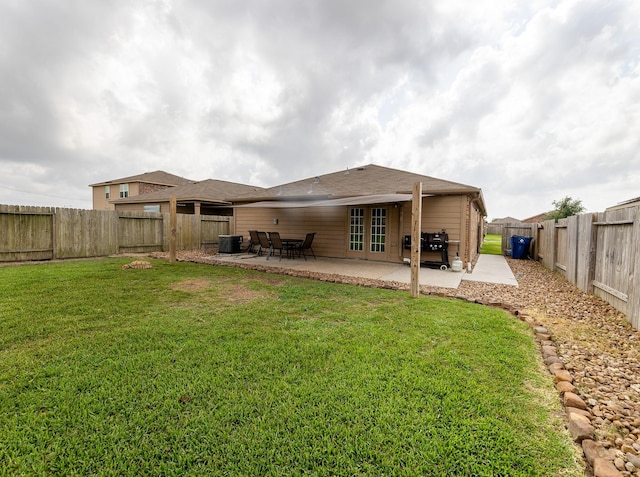 back of house featuring central air condition unit, french doors, a fenced backyard, a patio area, and a lawn