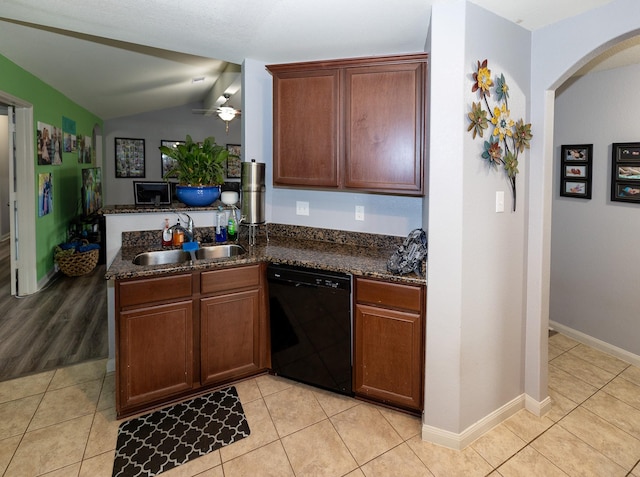 kitchen with light tile patterned flooring, a sink, dishwasher, a peninsula, and vaulted ceiling