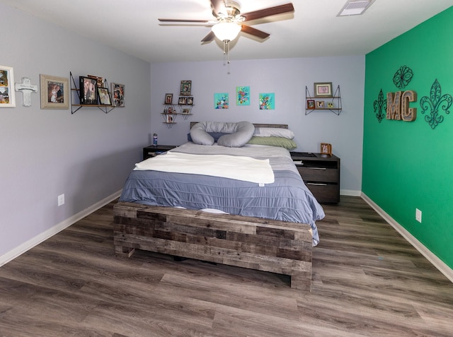 bedroom featuring baseboards, visible vents, and wood finished floors