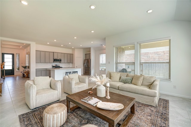 living area featuring a healthy amount of sunlight, light tile patterned floors, baseboards, and recessed lighting
