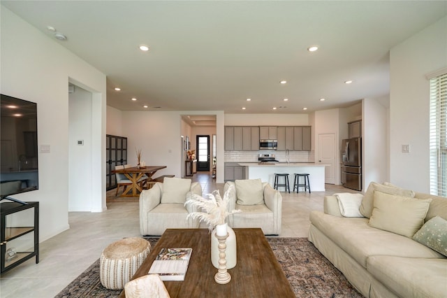 living area with light tile patterned flooring, baseboards, and recessed lighting
