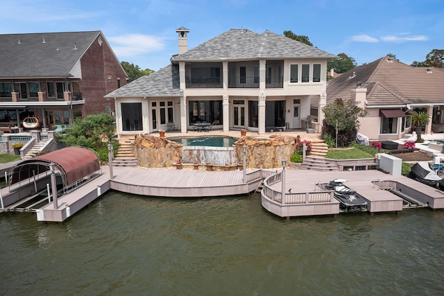 392 Green Cove Dr, Montgomery, TX 77356 - back of house with a water view, a chimney, stairs, and a patio area