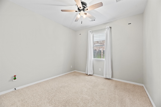 carpeted empty room with baseboards, a ceiling fan, and visible vents