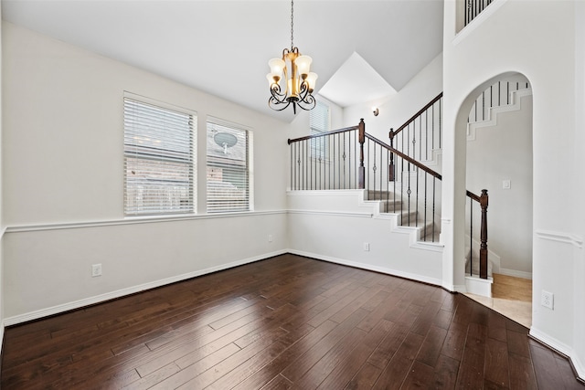 interior space featuring baseboards, hardwood / wood-style flooring, stairs, and a notable chandelier