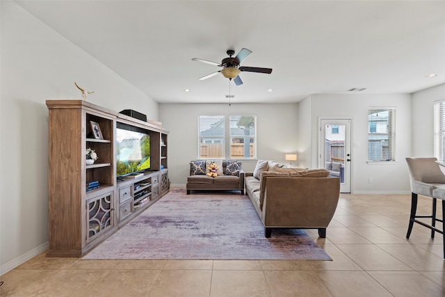 living area with visible vents, baseboards, ceiling fan, and light tile patterned floors