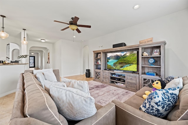 living area featuring arched walkways, baseboards, a ceiling fan, and recessed lighting
