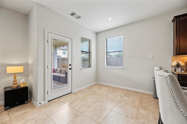 interior space featuring baseboards, light tile patterned flooring, and visible vents