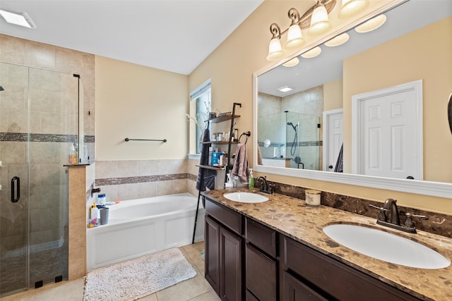 full bath featuring a sink, tile patterned flooring, a stall shower, and a garden tub