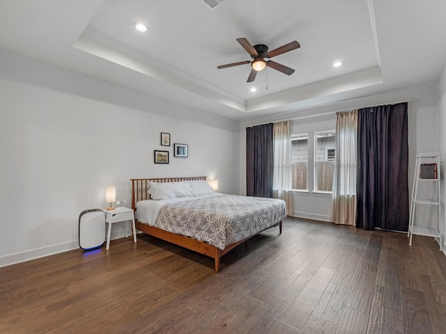 bedroom featuring wood-type flooring, recessed lighting, baseboards, and a tray ceiling