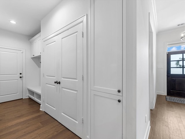 mudroom featuring visible vents, crown molding, baseboards, dark wood-style floors, and recessed lighting