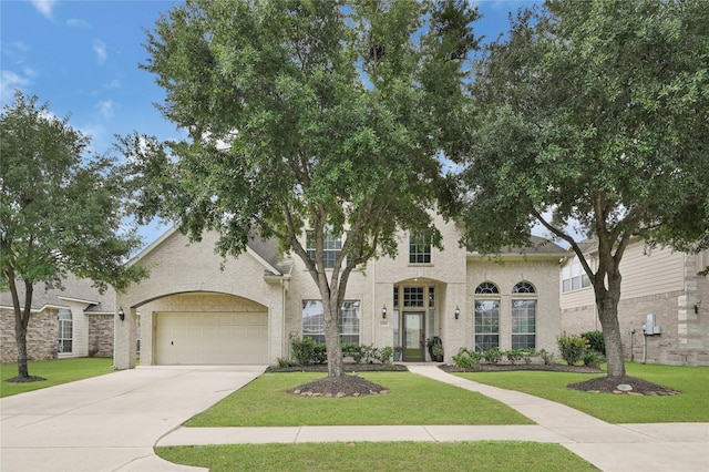 view of front of property with an attached garage, driveway, and a front lawn