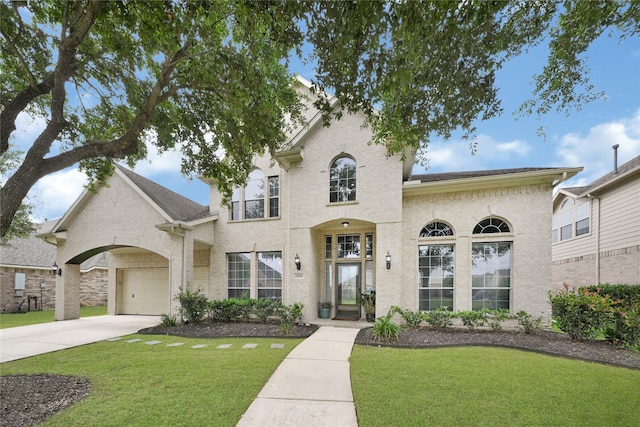 french provincial home with brick siding, an attached garage, driveway, and a front yard
