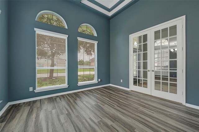 spare room with plenty of natural light, french doors, and wood finished floors